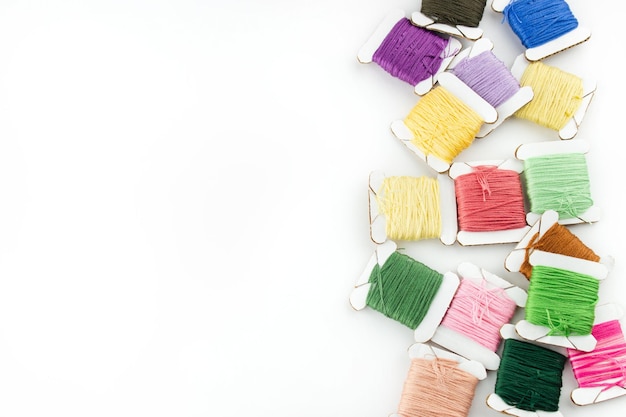 Kolorowe nici i igła na materiale